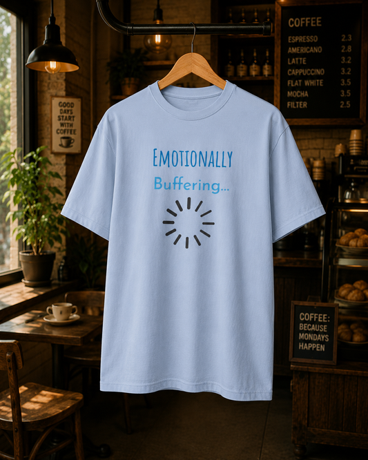 Light blue Mentally Buffering graphic T-shirt displayed on a hanger in a café