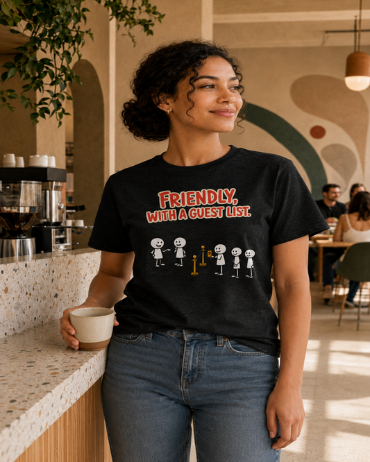 Woman wearing The Guest List black unisex graphic T-shirt in an earthy café